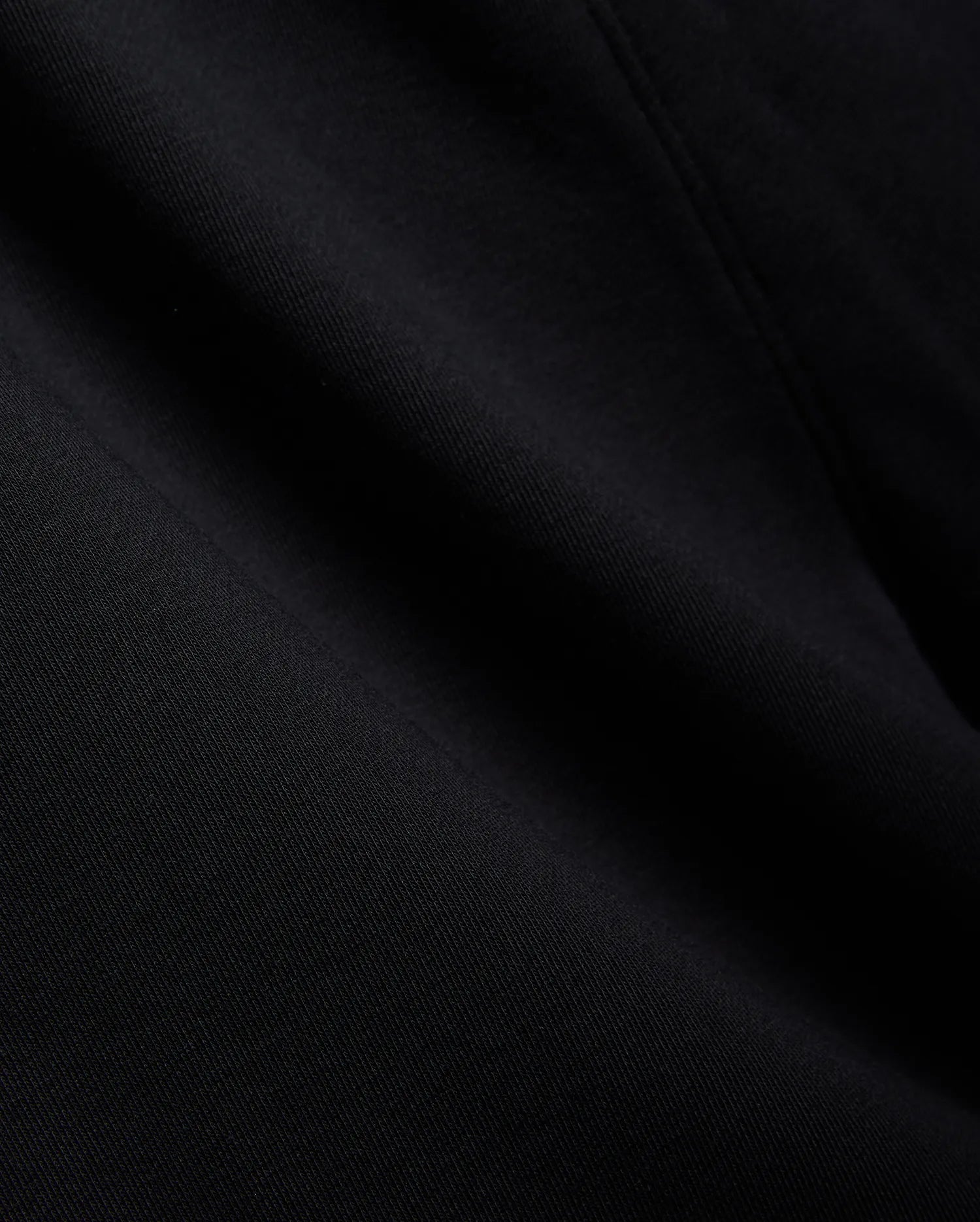 Mens Isaac Print Short in deep black, showcasing a premium, soft jersey knit fabric with a subtle, refined texture and gentle folds, embodying Psycho Bunny's quality.