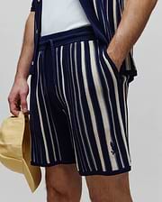 Mens Cliff Knit Short, navy blue and cream vertical striped knit shorts with a relaxed fit, drawstring waist, and small embroidered Psycho Bunny skull logo on the left leg. (2)