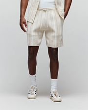 Mens Cliff Knit Short, cream relaxed-fit shorts featuring subtle light brown vertical stripes, a ribbed knit texture, drawstring waist, and a small embroidered Psycho Bunny skull logo on the lower left leg.