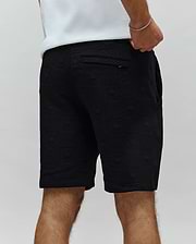 Mens Dustin Sweatshort, black textured knit with all-over embossed bunny skull logo pattern, relaxed fit, featuring a back pocket with a small Psycho Bunny tag.