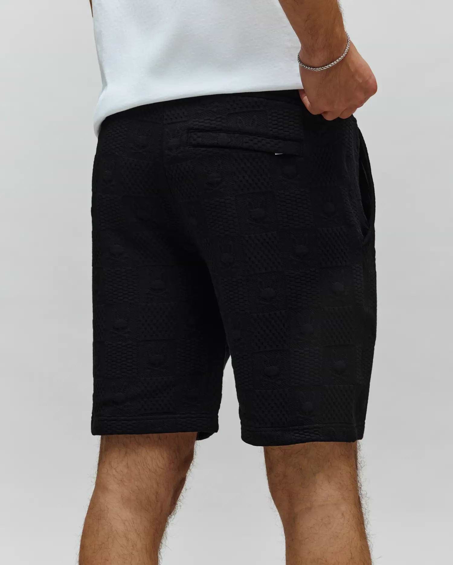Mens Dustin Sweatshort, black textured knit with all-over embossed bunny skull logo pattern, relaxed fit, featuring a back pocket with a small Psycho Bunny tag.