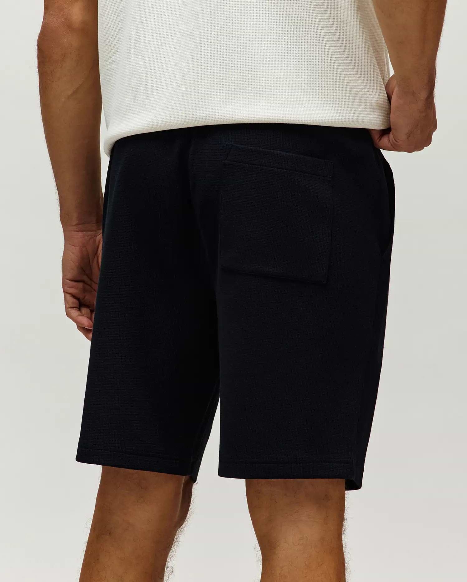 Black Mens Maxton Waffle Sweatshort, a relaxed fit streetwear style, featuring a textured waffle knit fabric, side pockets, and a back patch pocket.