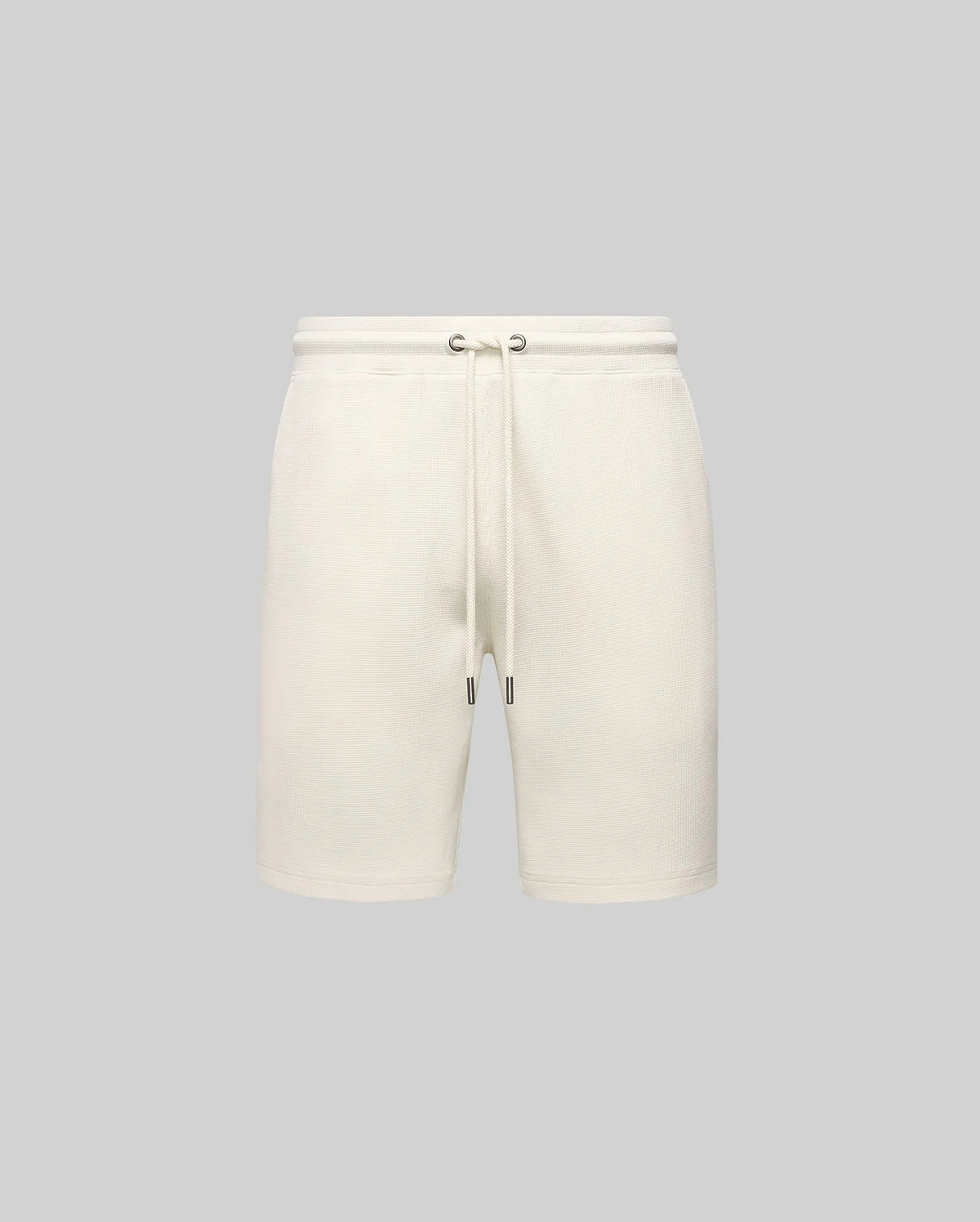 Mens Maxton Waffle Sweatshort in cream, a relaxed fit garment with textured waffle knit fabric, featuring an elastic drawstring waist, metal eyelets, and dark tips. No visible Psycho Bunny logo.