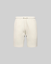 Mens Maxton Waffle Sweatshort in cream, a relaxed fit garment with textured waffle knit fabric, featuring an elastic drawstring waist, metal eyelets, and dark tips. No visible Psycho Bunny logo.