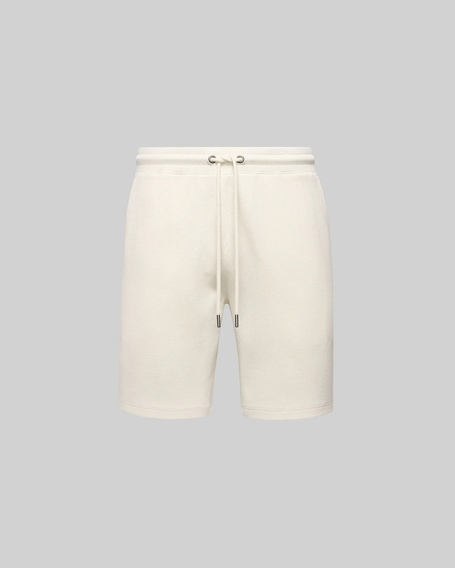 Mens Maxton Waffle Sweatshort in cream, a relaxed fit garment with textured waffle knit fabric, featuring an elastic drawstring waist, metal eyelets, and dark tips. No visible Psycho Bunny logo.