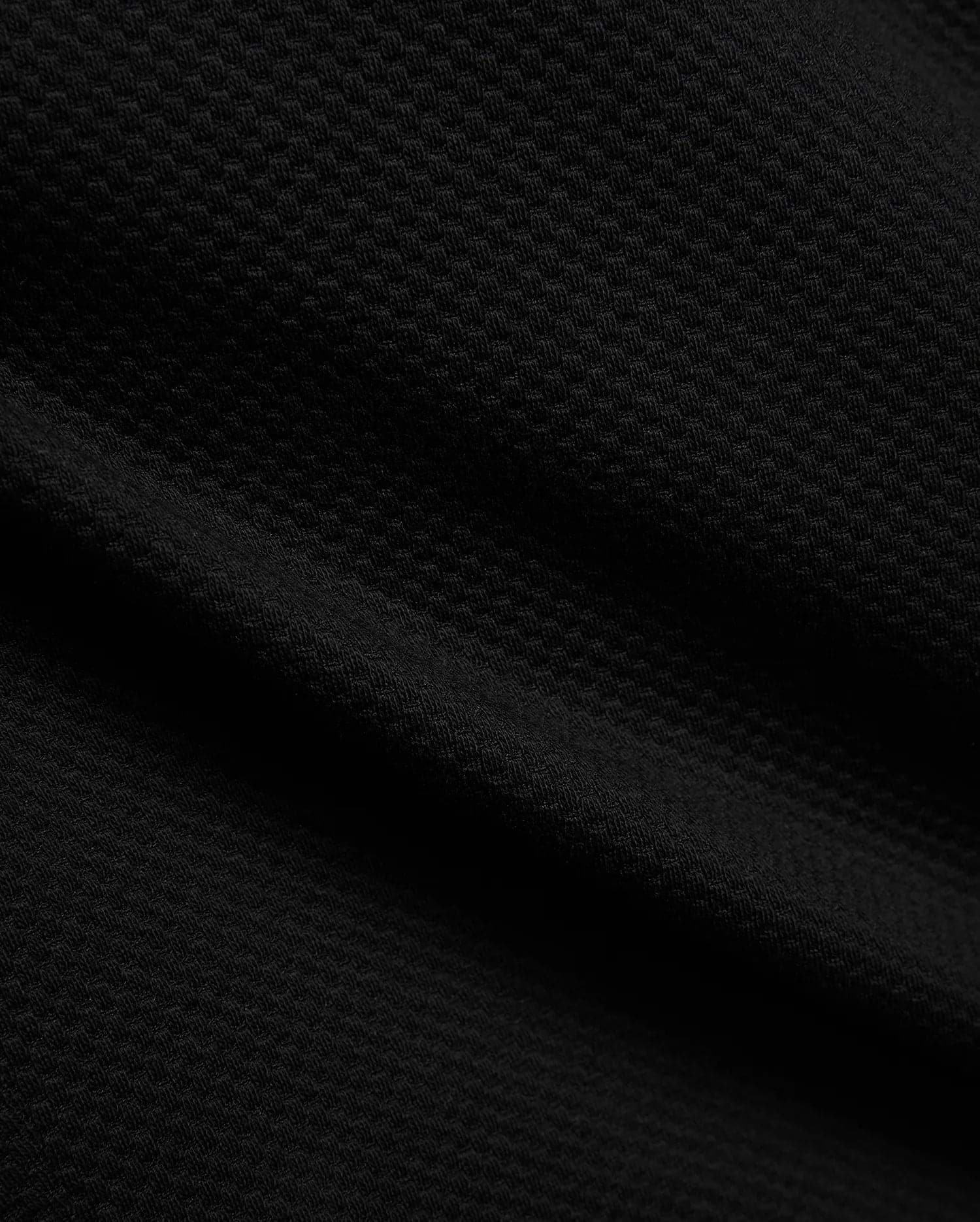 Mens Marc Textured Short in deep black, showcasing a premium, refined streetwear fabric with a distinctive, subtle geometric textured knit pattern, embodying Psycho Bunny's bold style.