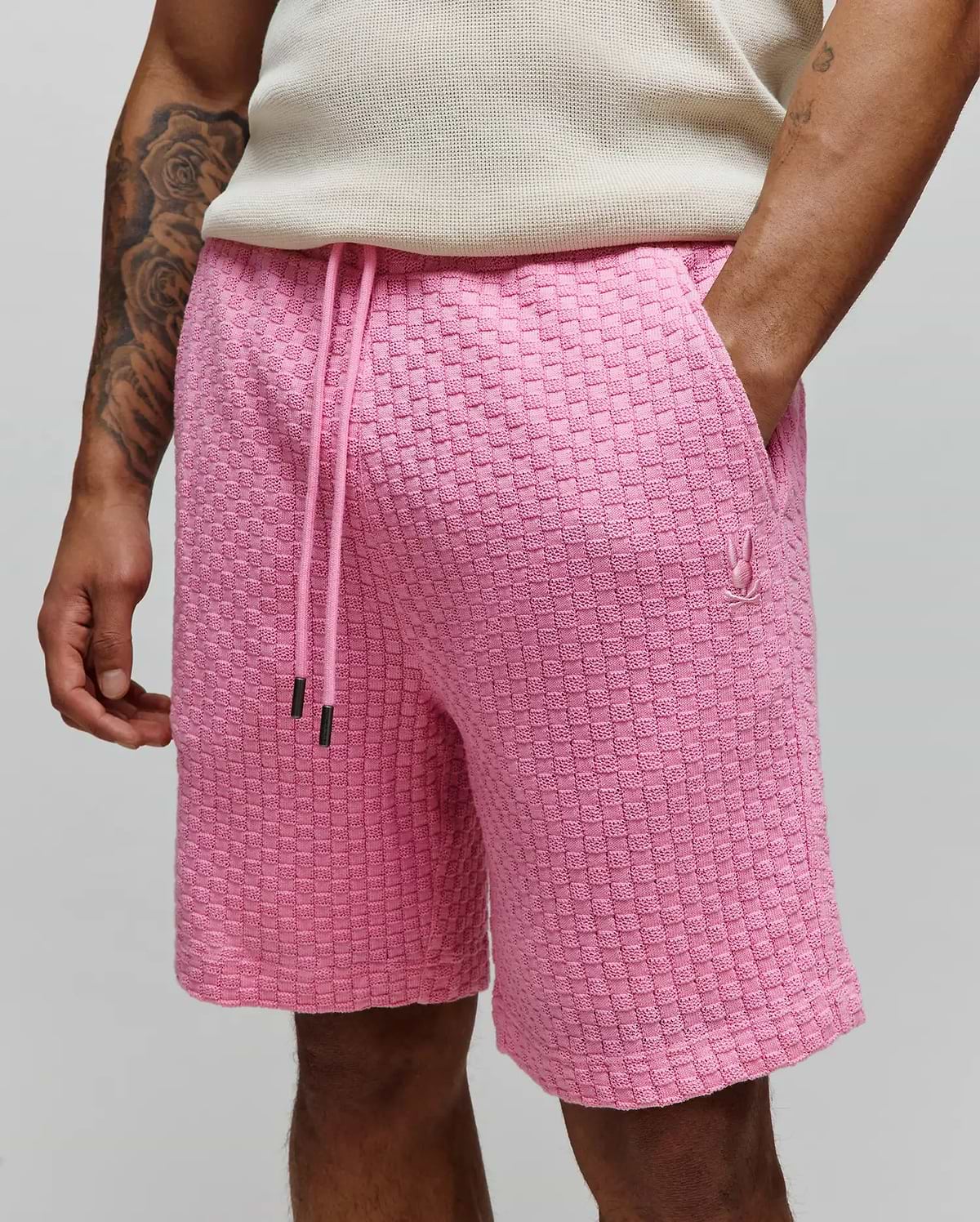 Mens Garen Knit Short in vibrant pink, featuring a relaxed fit, textured basketweave knit fabric, adjustable pink drawstring with black tips, and a small embroidered Psycho Bunny skull logo on the left thigh. (2)