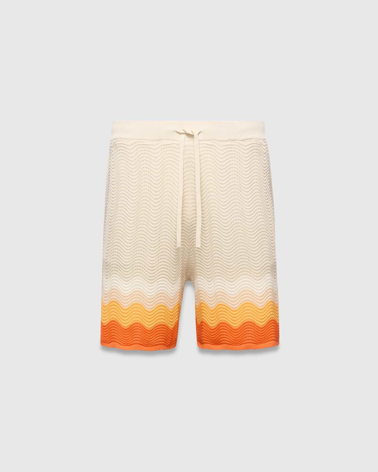 Mens Holden Knit Short in cream with a wavy knit texture, featuring a relaxed fit, drawstring waist, and a vibrant orange and yellow gradient stripe pattern at the hem.