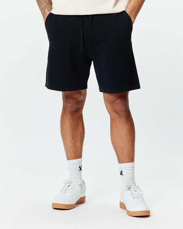 Mens Devon Knit Short, a premium black textured knit short from Psycho Bunny, featuring a comfortable relaxed fit, subtle geometric pattern, and an adjustable drawstring waist for refined streetwear style.