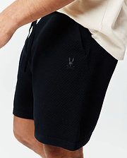Psycho Bunny Black Mens Devon Knit Short, a relaxed fit with textured knit fabric, drawstring waist, and small tonal embroidered bunny skull logo on the left thigh.