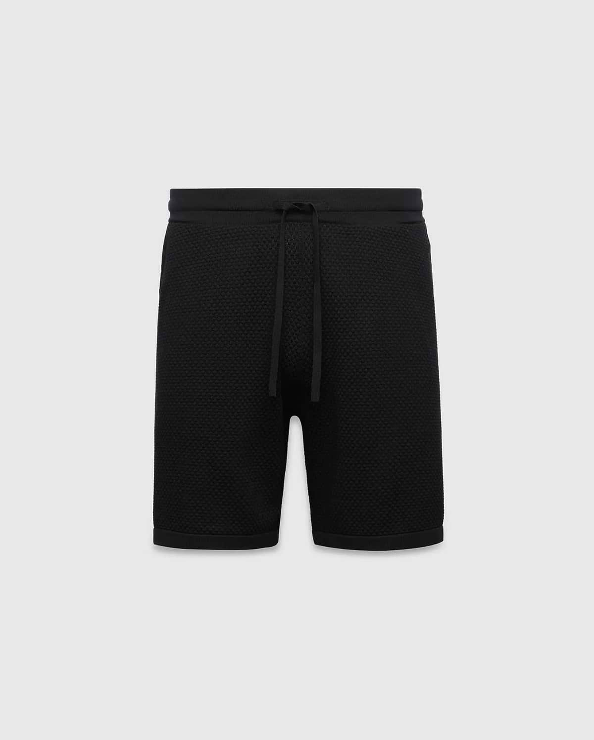 Black MENS DEVON KNIT SHORT with a relaxed fit, featuring a textured knit fabric, ribbed waistband, and drawstring closure. No visible Psycho Bunny logo.