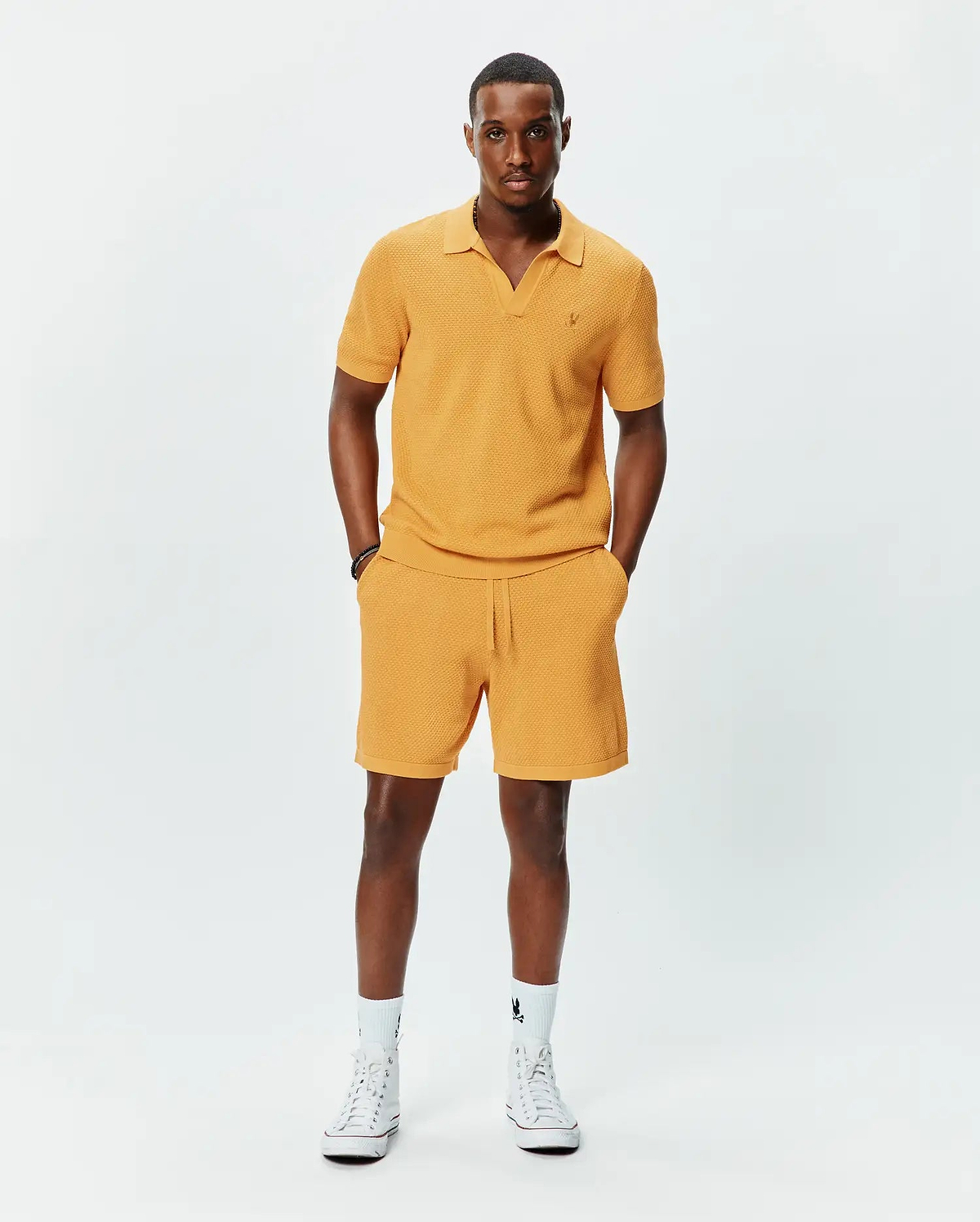 Mustard yellow textured knit polo with V-neck and small embroidered Psycho Bunny logo on left chest, paired with matching Mens Devon Knit Short with drawstring waist.