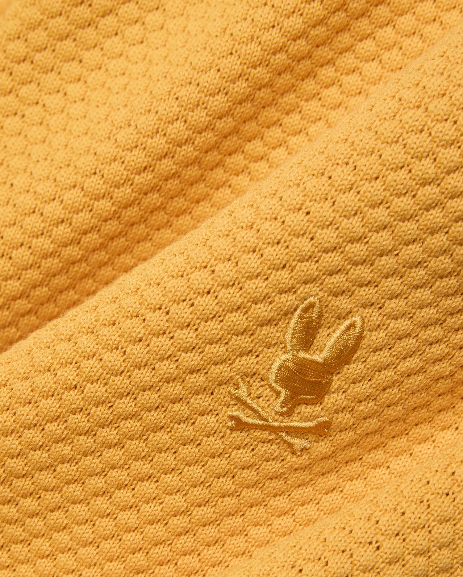 Mustard yellow Mens Devon Knit Short crafted from a textured knit fabric with a subtle geometric pattern, featuring a small, tonal embroidered Psycho Bunny skull logo.