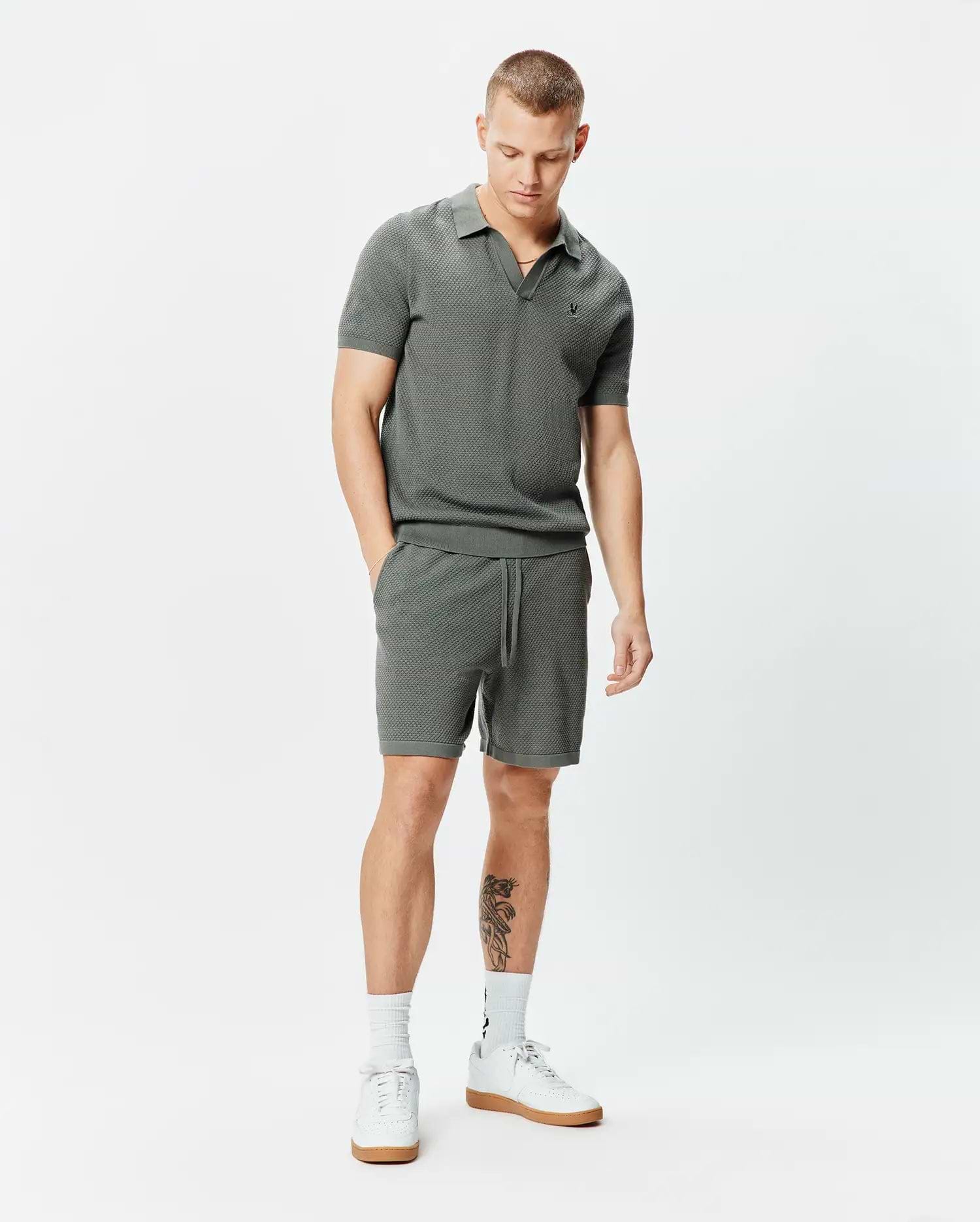 Charcoal grey pique knit polo shirt with small embroidered Psycho Bunny skull logo on left chest and matching Mens Devon Knit Short 7 with drawstring waist, both in a classic fit.