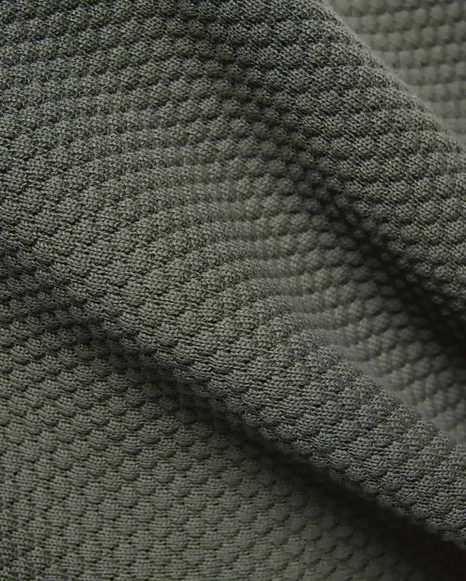 Mens Devon Knit Short 7 in premium dark olive green, showcasing a sophisticated, breathable textured pique knit fabric, reflecting refined streetwear quality.
