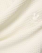 Mens Devon Knit Short in premium cream, featuring a soft, subtly patterned open knit fabric and a small, tone-on-tone embroidered Psycho Bunny skull logo detail.
