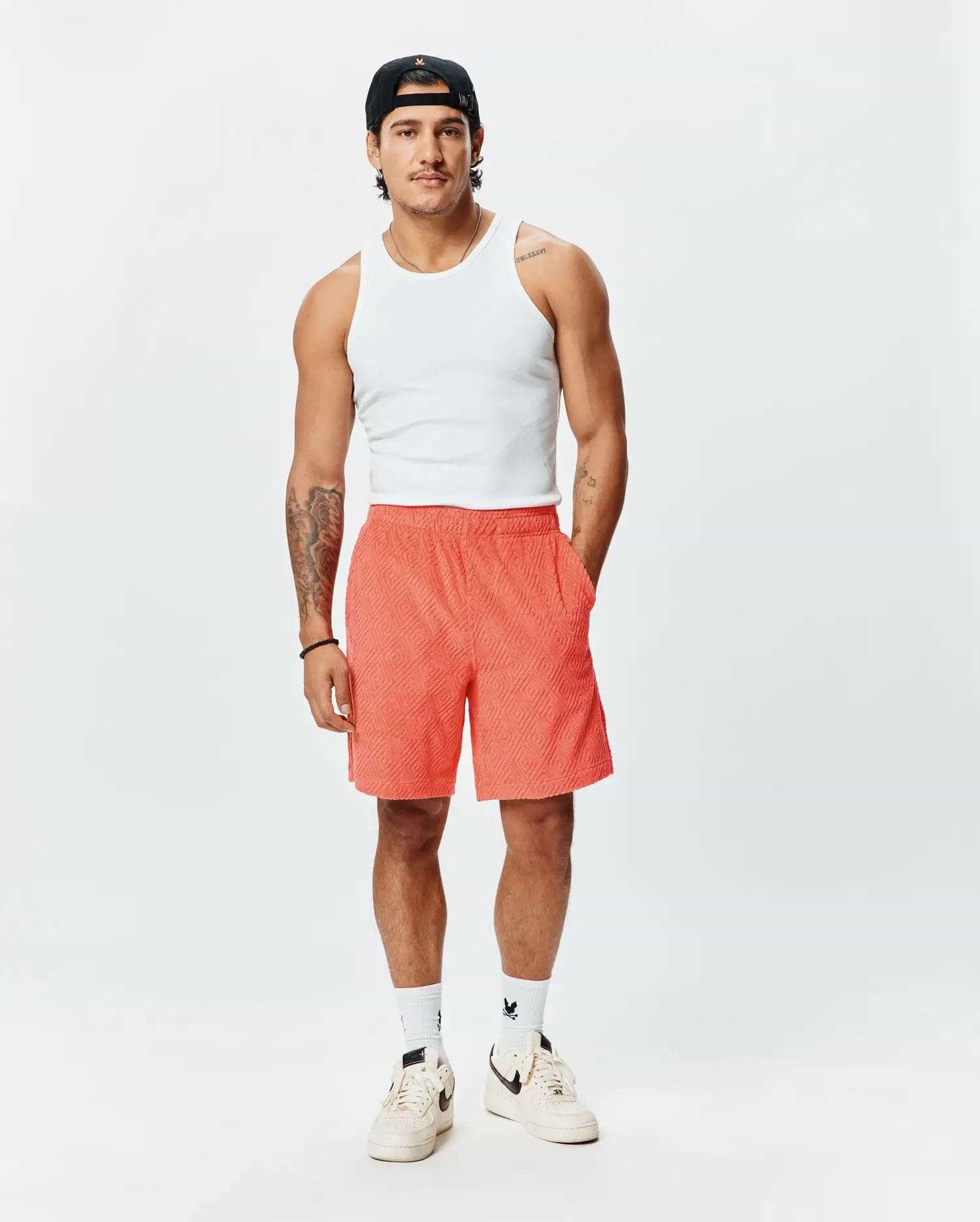 Mens Tristan Short, a premium Psycho Bunny relaxed fit short in vibrant coral, featuring an all-over embossed geometric diamond pattern and practical side pockets. (4)