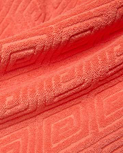 Mens Tristan Short in bold coral terry cloth, featuring a luxurious plush texture and an intricate, all-over embossed geometric maze pattern, reflecting refined streetwear style. (6)