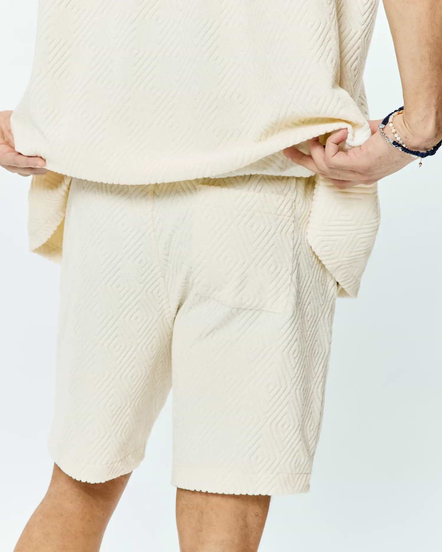 Psycho Bunny Mens Tristan Short in cream, a relaxed fit, soft textured fabric with an all-over embossed geometric diamond pattern.