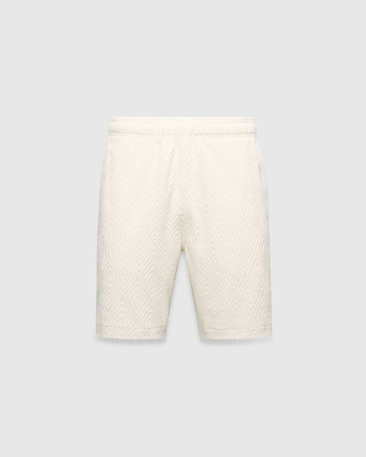 Mens Tristan Short in cream, a relaxed fit short with an all-over raised geometric concentric square pattern on textured fabric, no visible Psycho Bunny logo.