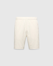 Mens Tristan Short in cream, a relaxed fit short with an all-over raised geometric concentric square pattern on textured fabric, no visible Psycho Bunny logo.
