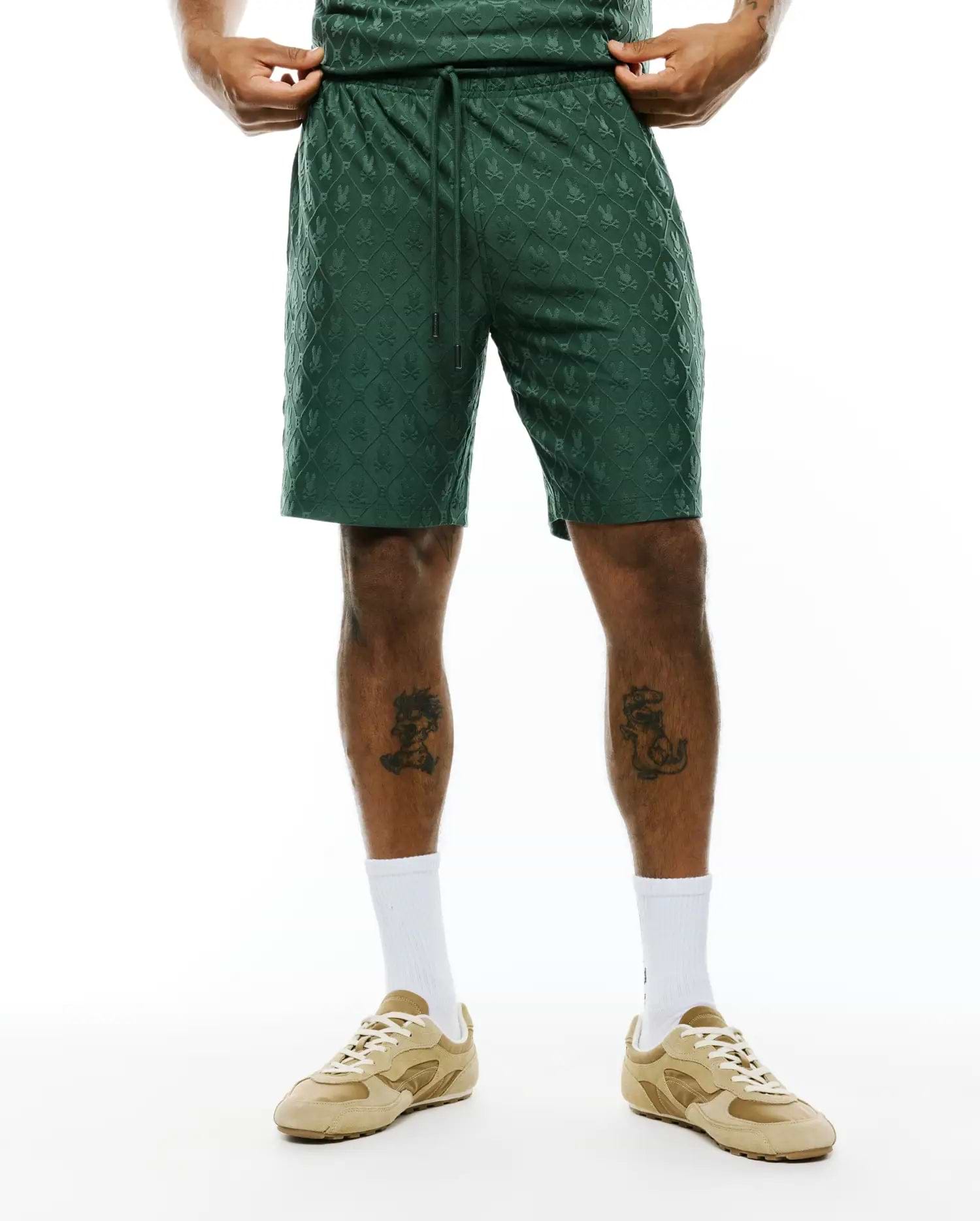 Deep green MENS GARRY JACQUARD SWEATSHORT, featuring a relaxed fit and an all-over subtle jacquard knit pattern of the iconic Psycho Bunny skull logo within a diamond grid, with a drawstring waist.