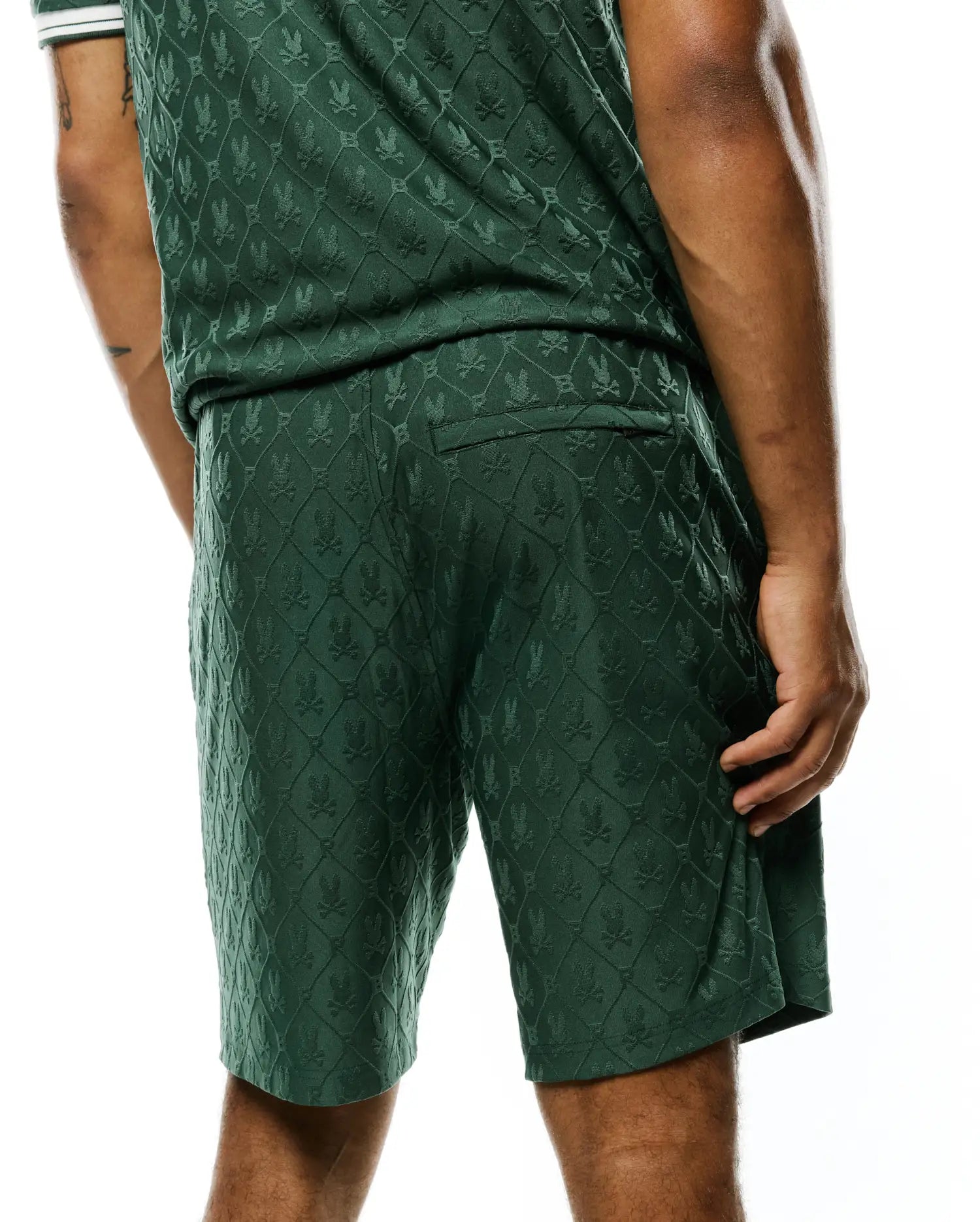 MENS GARRY JACQUARD SWEATSHORT in dark green, featuring a relaxed fit and an all-over jacquard knit pattern of the iconic Psycho Bunny skull logo within a diamond grid.