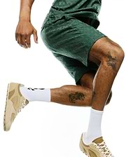 Mens Garry Jacquard Sweatshort in dark green, featuring a relaxed fit and an all-over tonal jacquard knit pattern of the iconic Psycho Bunny skull logo, with subtle lighter green side piping.