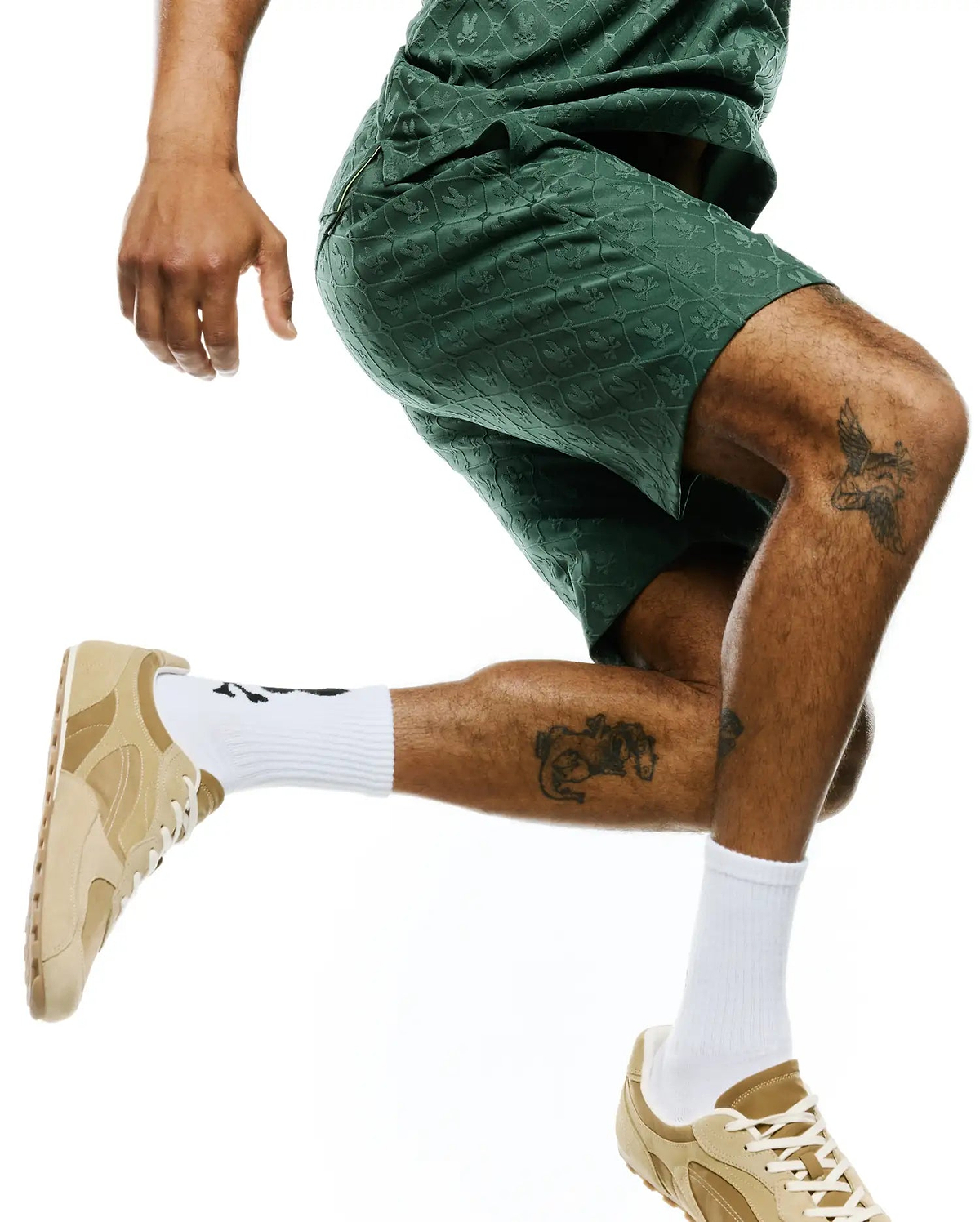 Mens Garry Jacquard Sweatshort in dark green, featuring a relaxed fit and an all-over tonal jacquard knit pattern of the iconic Psycho Bunny skull logo, with subtle lighter green side piping.