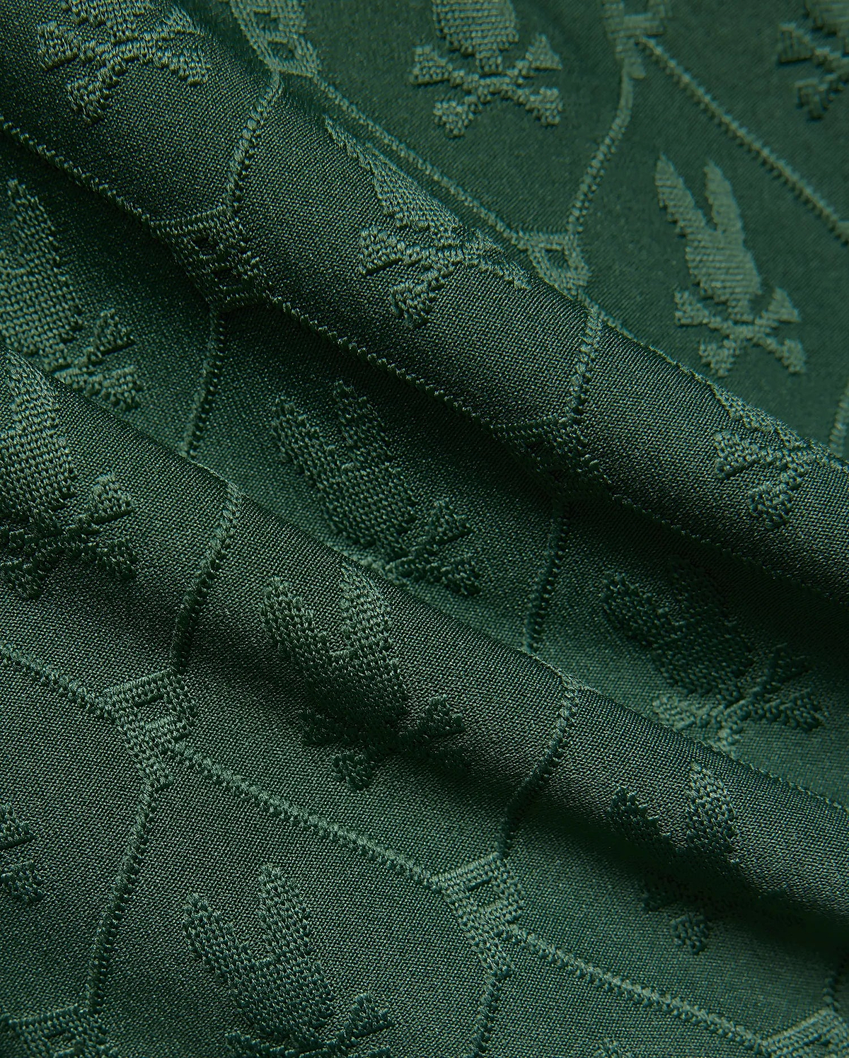 Mens Garry Jacquard Sweatshort in deep forest green, featuring a subtle all-over jacquard knit pattern of the iconic Psycho Bunny skull logo, creating a rich, textured fabric.