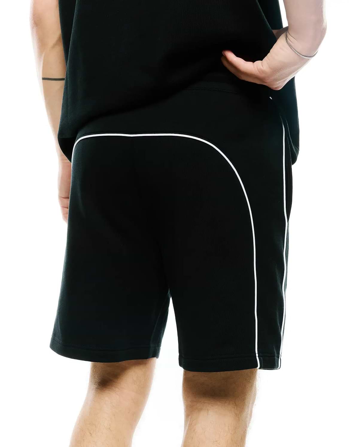 Mens Stevie Short, black relaxed fit jersey shorts featuring prominent white contrast piping that curves across the upper back and extends down the side seams, offering a refined streetwear aesthetic.