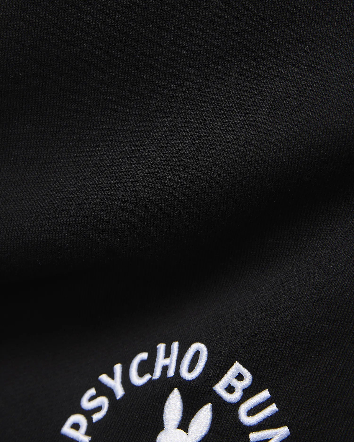 Mens Stevie Short in black, crafted from a smooth, dense knit fabric, prominently featuring the iconic white embroidered Psycho Bunny text and partial bunny skull logo.