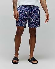 Mens Luke Swim Trunk, a classic fit, navy blue swim trunk with an all-over ornate floral and paisley pattern in pink, light blue, purple, and white, featuring integrated Psycho Bunny skull logos.