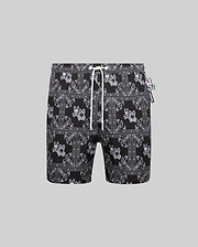 Mens Luke Swim Trunk, black with white all-over bandana print featuring the iconic Psycho Bunny skull logo, relaxed fit, smooth quick-dry fabric, white drawstring, and small Psycho Bunny tag.