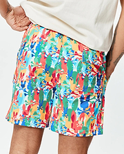 Mens Tanner Swim Trunk in a vibrant multi-color all-over print featuring Psycho Bunny skull logos, surfboards, and crossbones on a white background, crafted from smooth, quick-dry fabric with a relaxed fit.