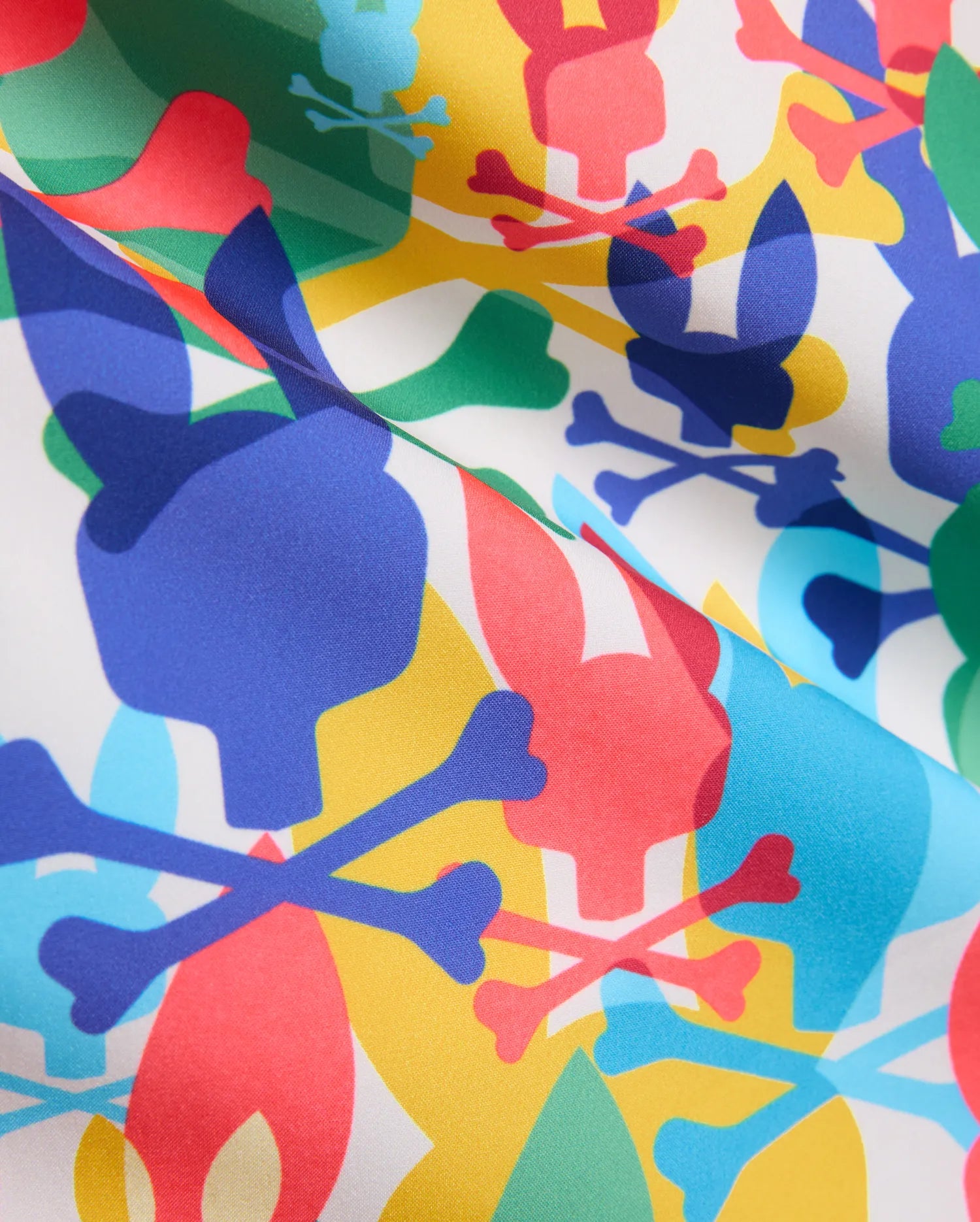 Mens Tanner Swim Trunk with a vibrant all-over print on white smooth woven fabric, featuring overlapping blue, red, yellow, green, and light blue Psycho Bunny skull and crossbones logos.