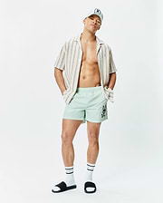 Mens Neo Swim Trunk 5 in mint green, featuring a classic fit and smooth, quick-dry fabric, with a large black Psycho Bunny skull logo prominently on the left thigh. (4)