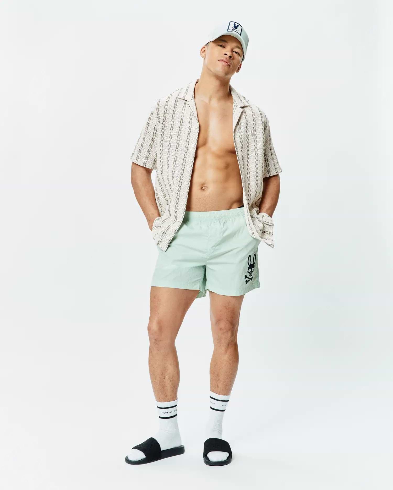 Mens Neo Swim Trunk 5 in mint green, featuring a classic fit and smooth, quick-dry fabric, with a large black Psycho Bunny skull logo prominently on the left thigh. (4)