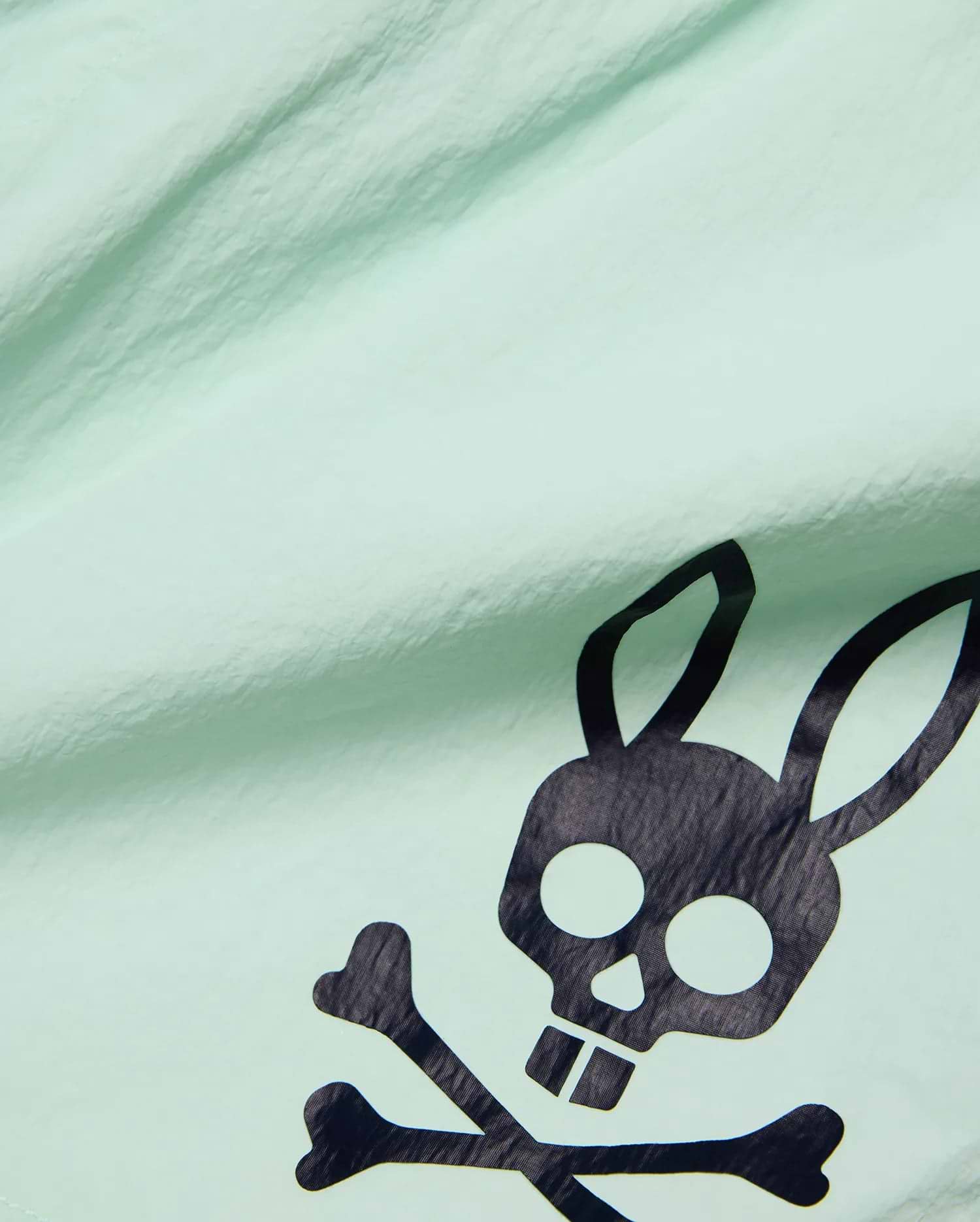 Mens Neo Swim Trunk 4 in vibrant mint green, crafted from lightweight, crinkled fabric, featuring a bold, large black Psycho Bunny skull and crossbones logo prominently displayed. (6)