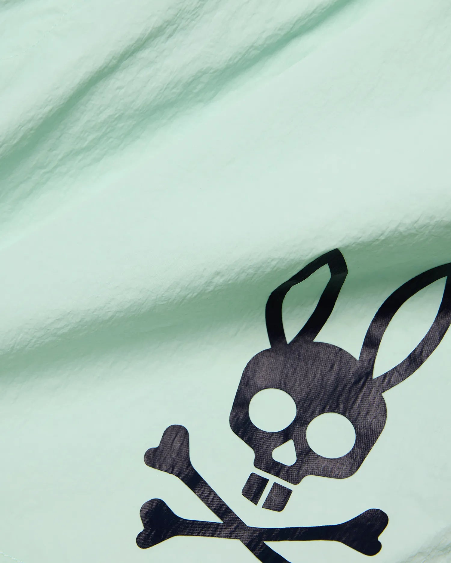 Mens Neo Swim Trunk 4 in vibrant mint green, crafted from lightweight, crinkled fabric, featuring a bold, large black Psycho Bunny skull and crossbones logo prominently displayed. (6)