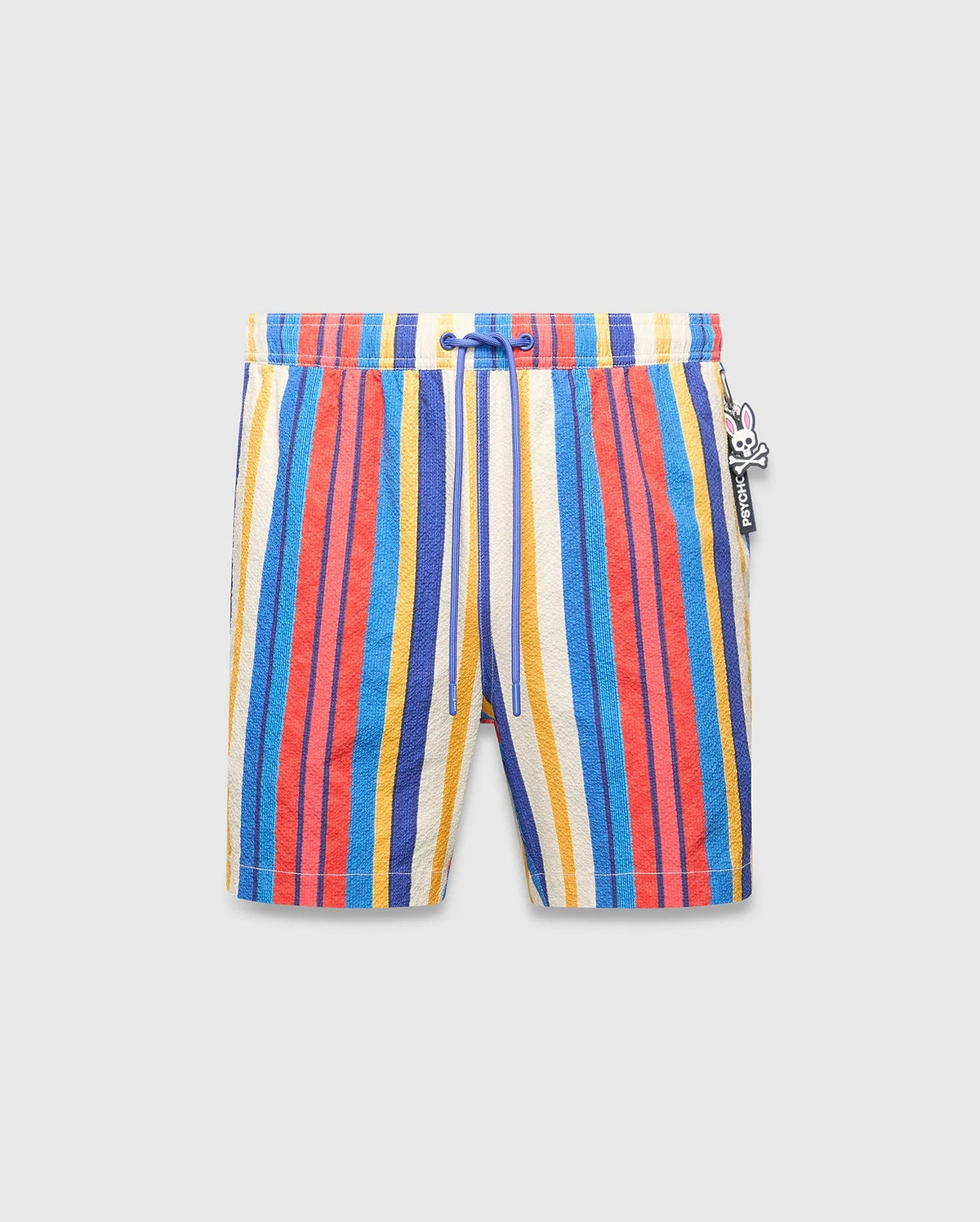 Mens Hubert Swim Trunk featuring vibrant multi-color vertical stripes in cream, blue, red, and yellow, with a textured fabric, royal blue drawstring, and a small Psycho Bunny skull logo charm on the right side.