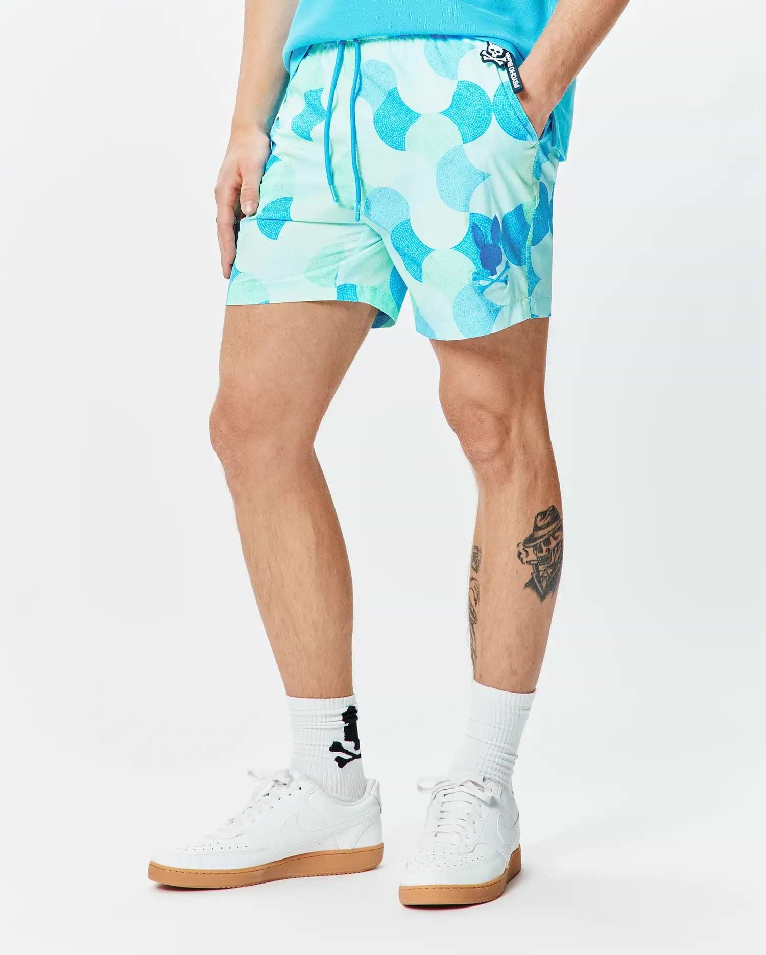 Mens Ethan Swim Trunk 6, featuring a vibrant mint green and blue mosaic pattern, classic fit, smooth fabric, with a small Psycho Bunny skull logo on the left leg and a branded pocket label.