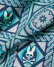Mens Frank Swim Trunk 6, a navy blue fabric with a detailed mosaic print in teal, light green, and white, featuring the repeated iconic Psycho Bunny skull logo. (6)