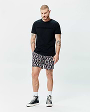 Black classic fit jersey t-shirt with a tonal, raised Psycho Bunny chest logo, paired with Mens Byron Swim Trunk 6 featuring an all-over vibrant bunny skull print. (4)