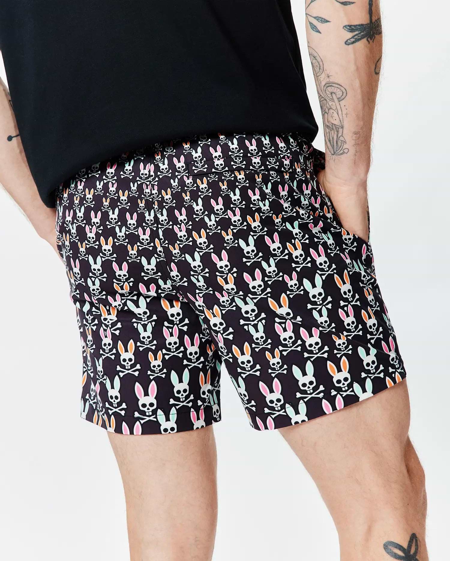 Mens Byron Swim Trunk 6, black with an all-over Psycho Bunny skull and crossbones pattern in pink, orange, mint green, and white, featuring a relaxed fit and smooth quick-dry fabric. (2)