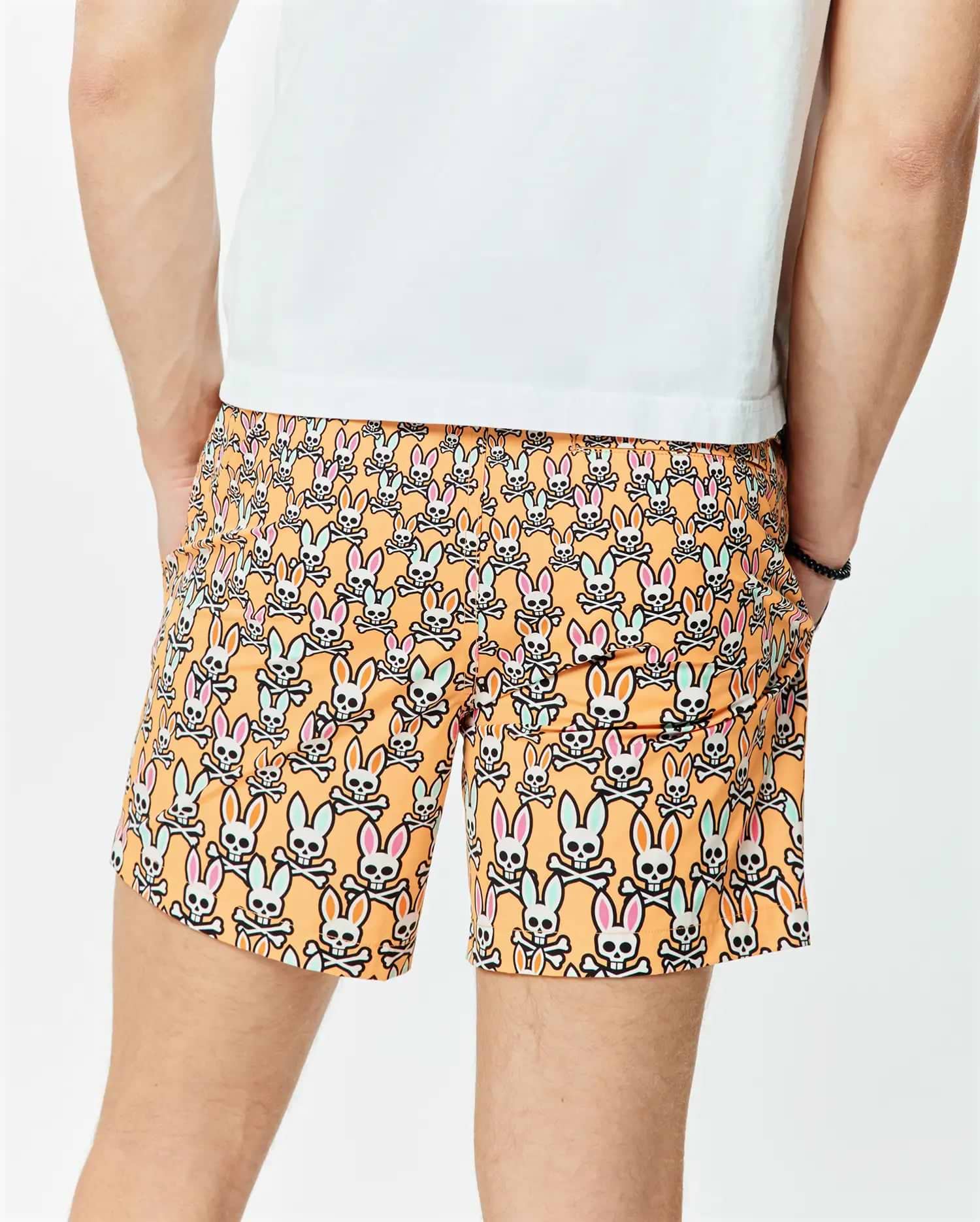 Mens Byron Swim Trunk 6 in vibrant orange, featuring an all-over print of white Psycho Bunny skull logos with pink and light blue ears, crafted from smooth, quick-dry fabric for a relaxed fit.