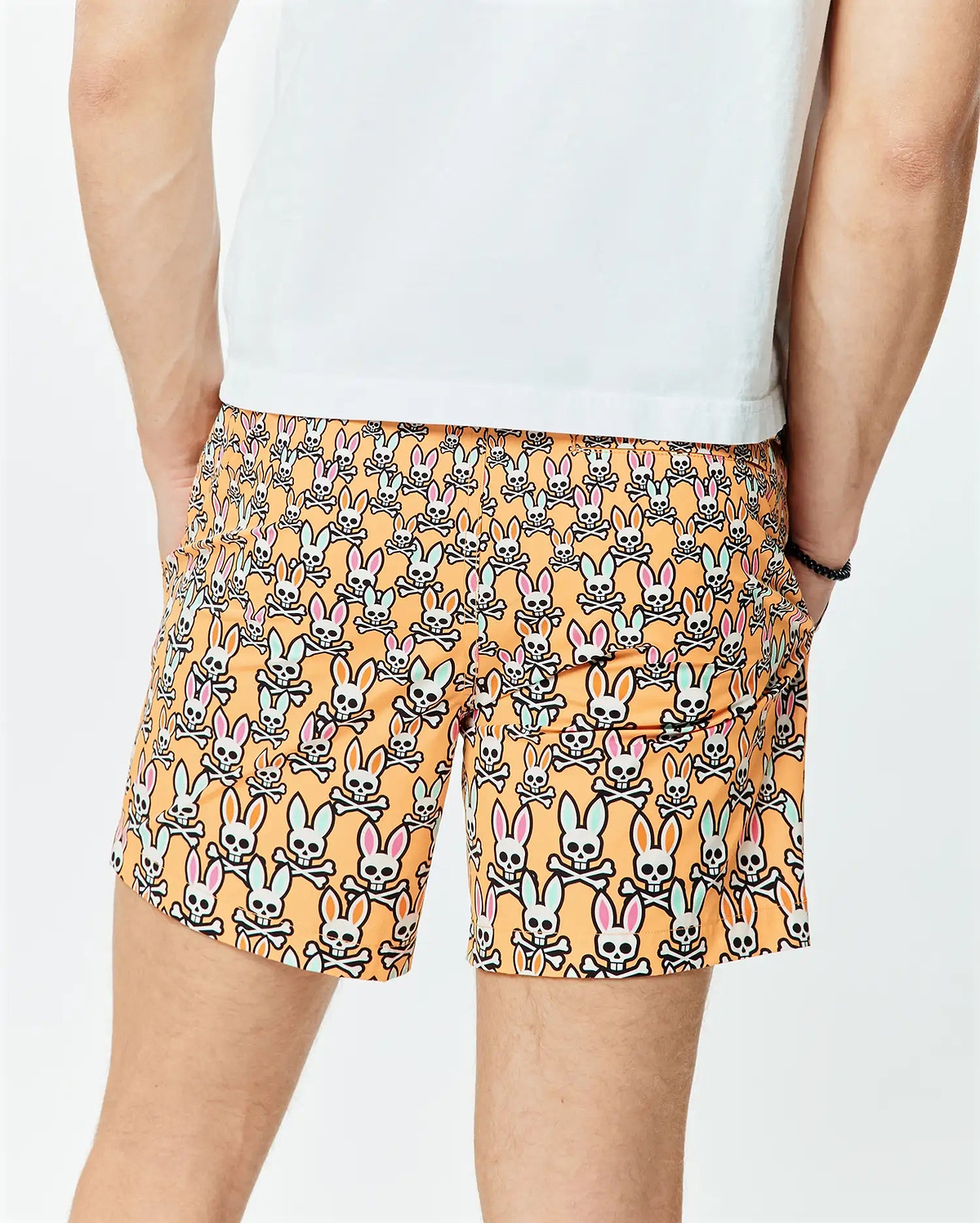 Mens Byron Swim Trunk 6 in vibrant orange, featuring an all-over print of white Psycho Bunny skull logos with pink and light blue ears, crafted from smooth, quick-dry fabric for a relaxed fit.
