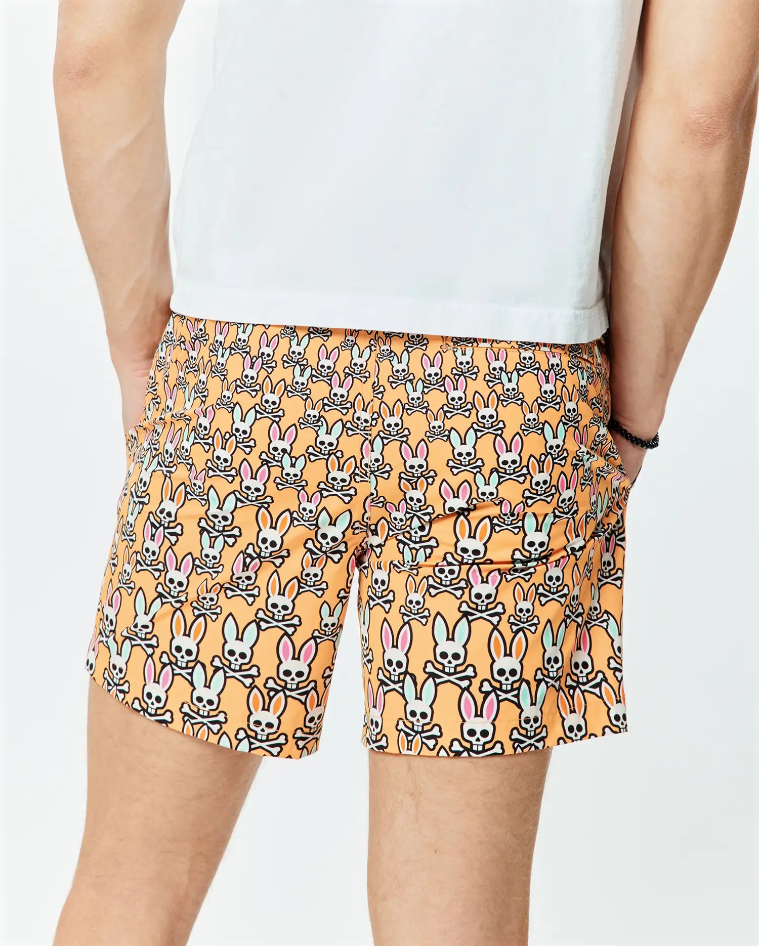 Mens Byron Swim Trunk 6 in vibrant orange, featuring an all-over print of white Psycho Bunny skull logos with pink and light blue ears, crafted from smooth, quick-dry fabric for a relaxed fit.