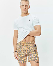 White classic fit jersey t-shirt with small embroidered Psycho Bunny logo on left chest, paired with orange Mens Byron Swim Trunk 6 featuring an all-over multi-color bunny skull print and drawstring waist.