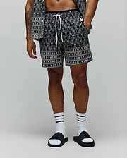 Mens Keon All Over Bunny Swim Trunk, black with a white all-over bunny skull pattern, classic fit, smooth woven fabric, featuring a white drawstring and a black elastic waistband with white Psycho Bunny text. (1)
